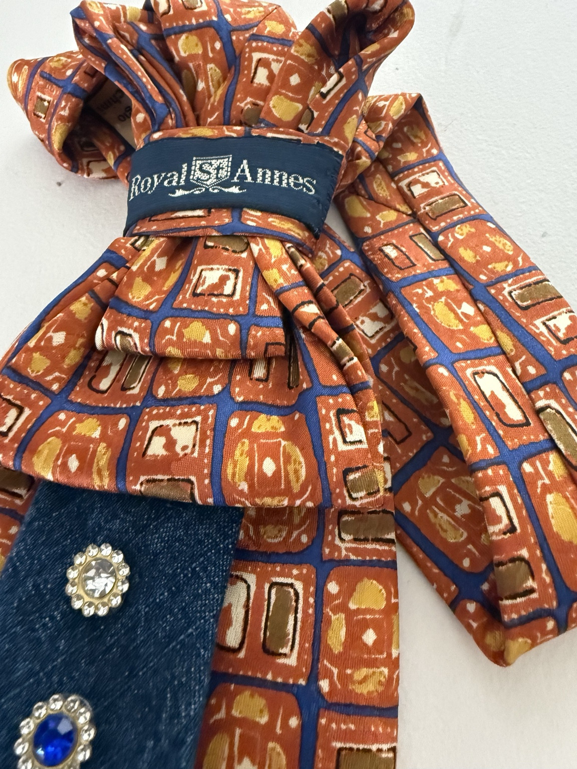 Pieghe sartoriali e trama arancio di una cravatta gioiello